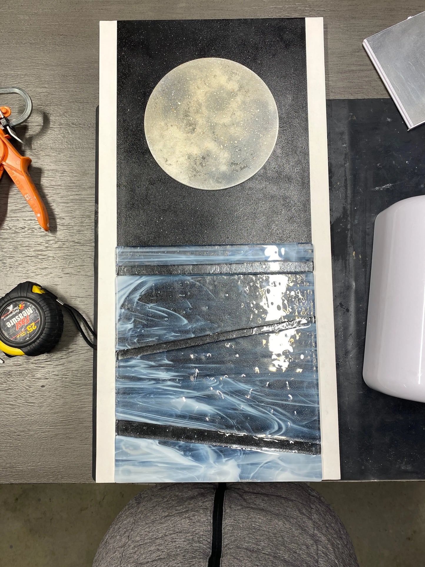 Mixed‑media artwork featuring a resin moon infused with ashes and frosted glass water elements, created as a memorial piece for a family member.