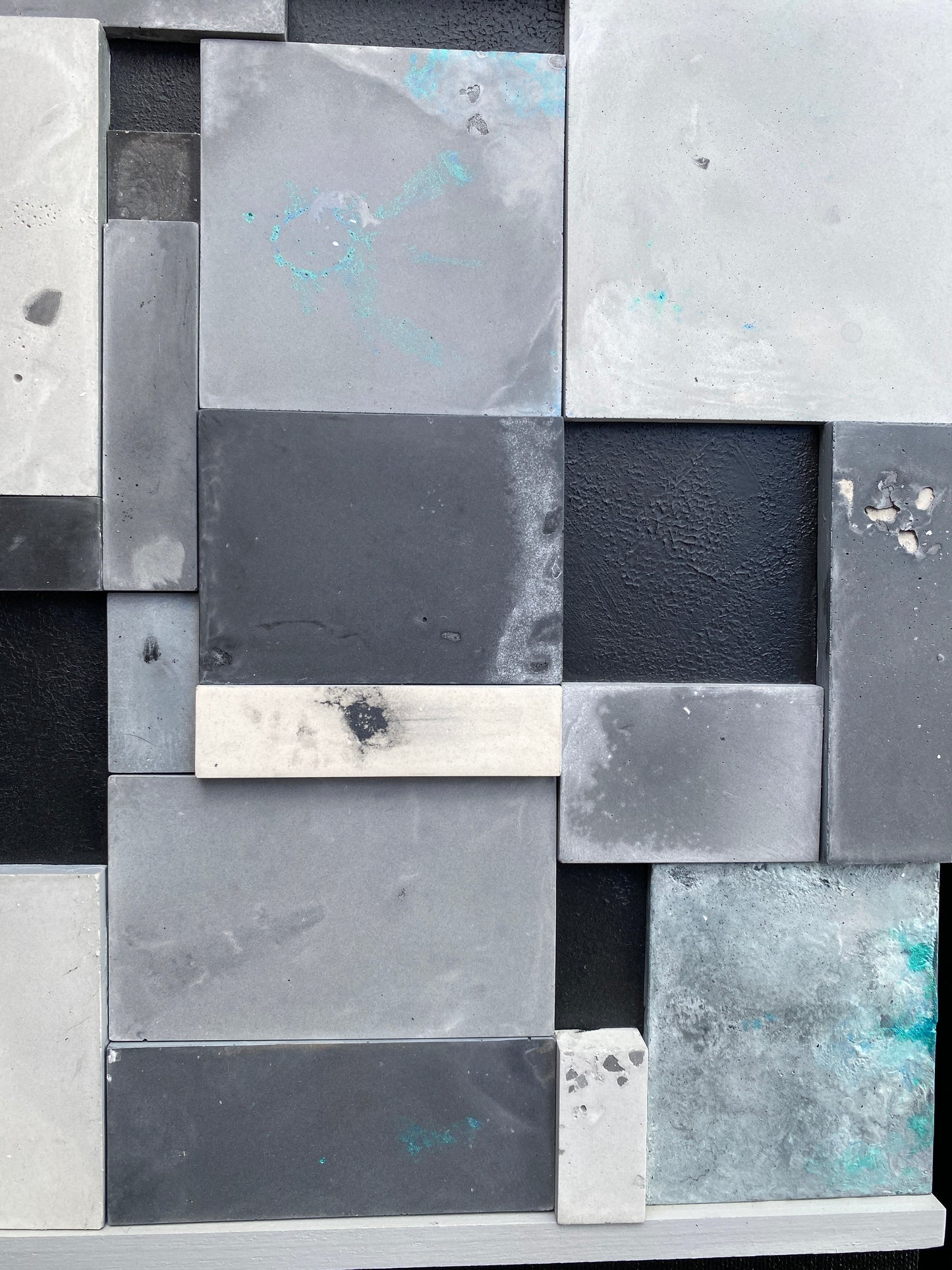 Pattern of square tiles in various shades of gray and black.