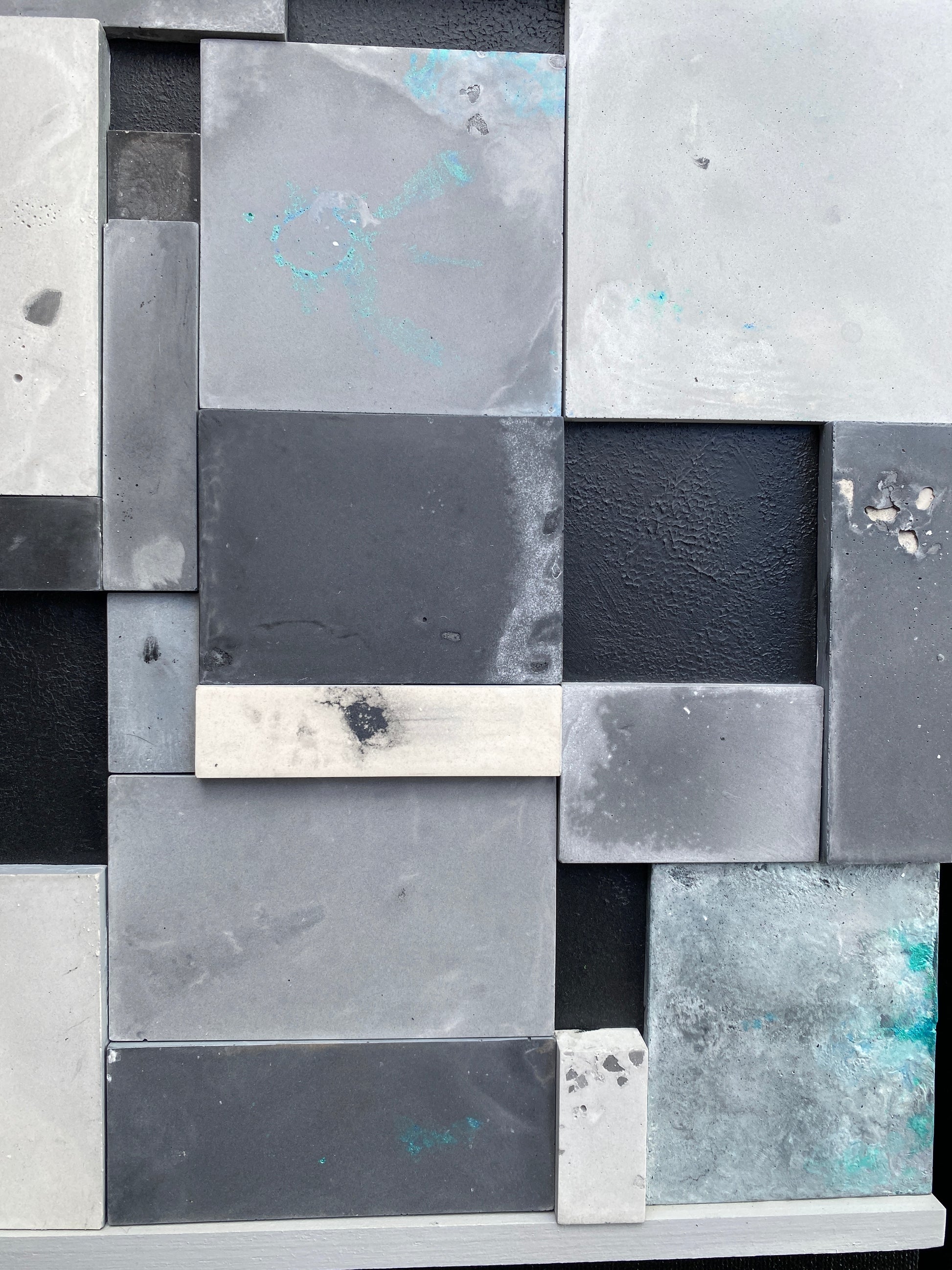 Pattern of square tiles in various shades of gray and black.