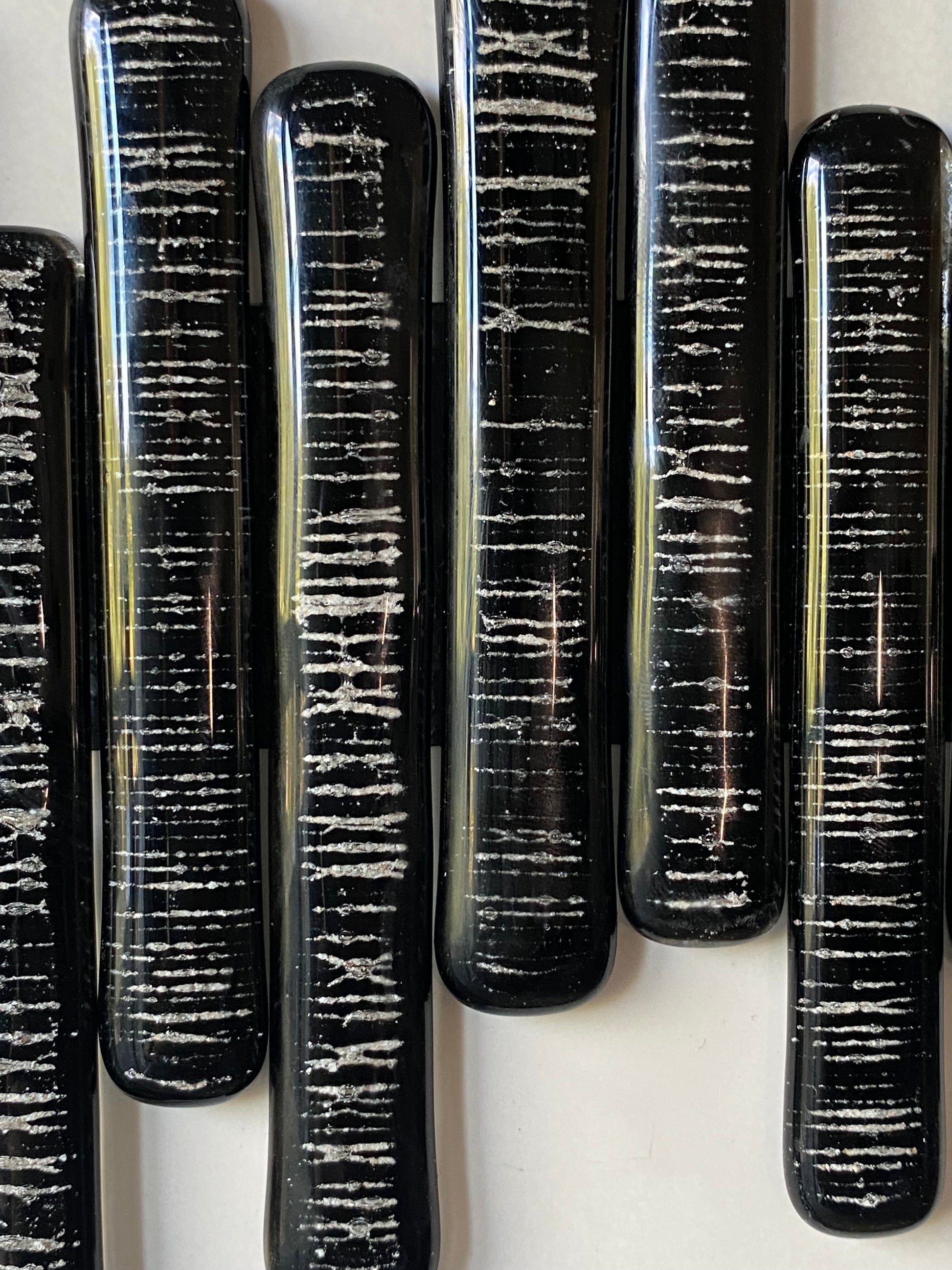 Close-up of glass pieces infused with cremation ash, forming a soundwave pattern symbolizing heartbeat and presence