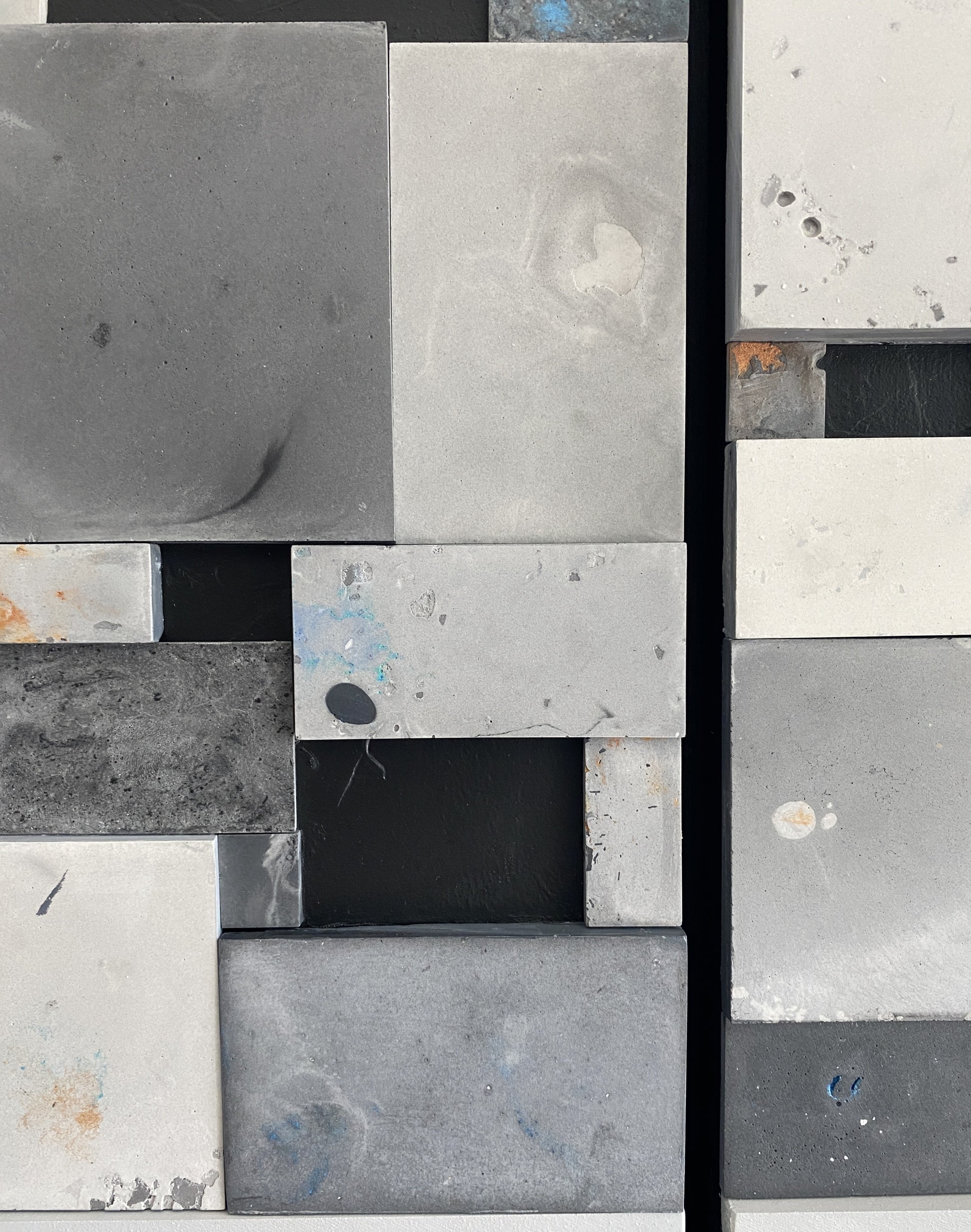 Close-up of a patterned tile with gray, black, and white squares.