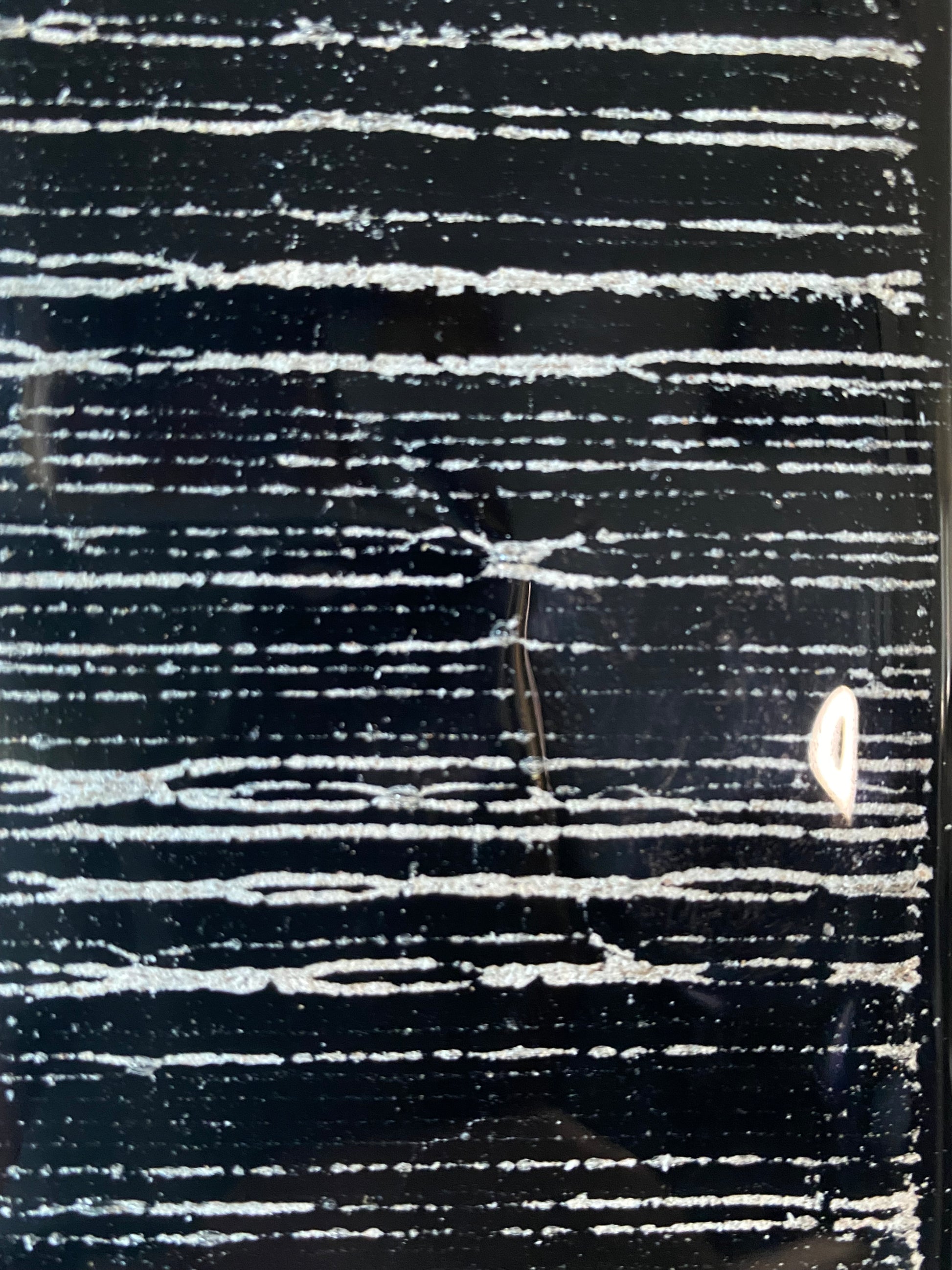 Close-up of flowing glass stripes infused with cremation ash, symbolizing stability and connection