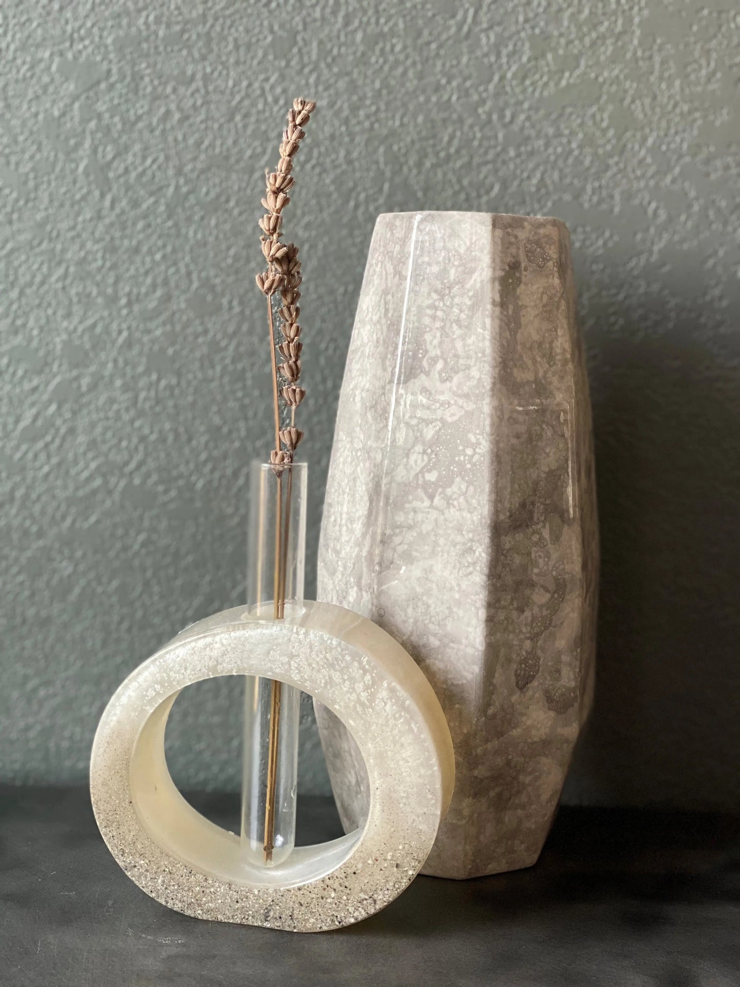 Decorative stone vase with a circular base and textured surface against a gray background