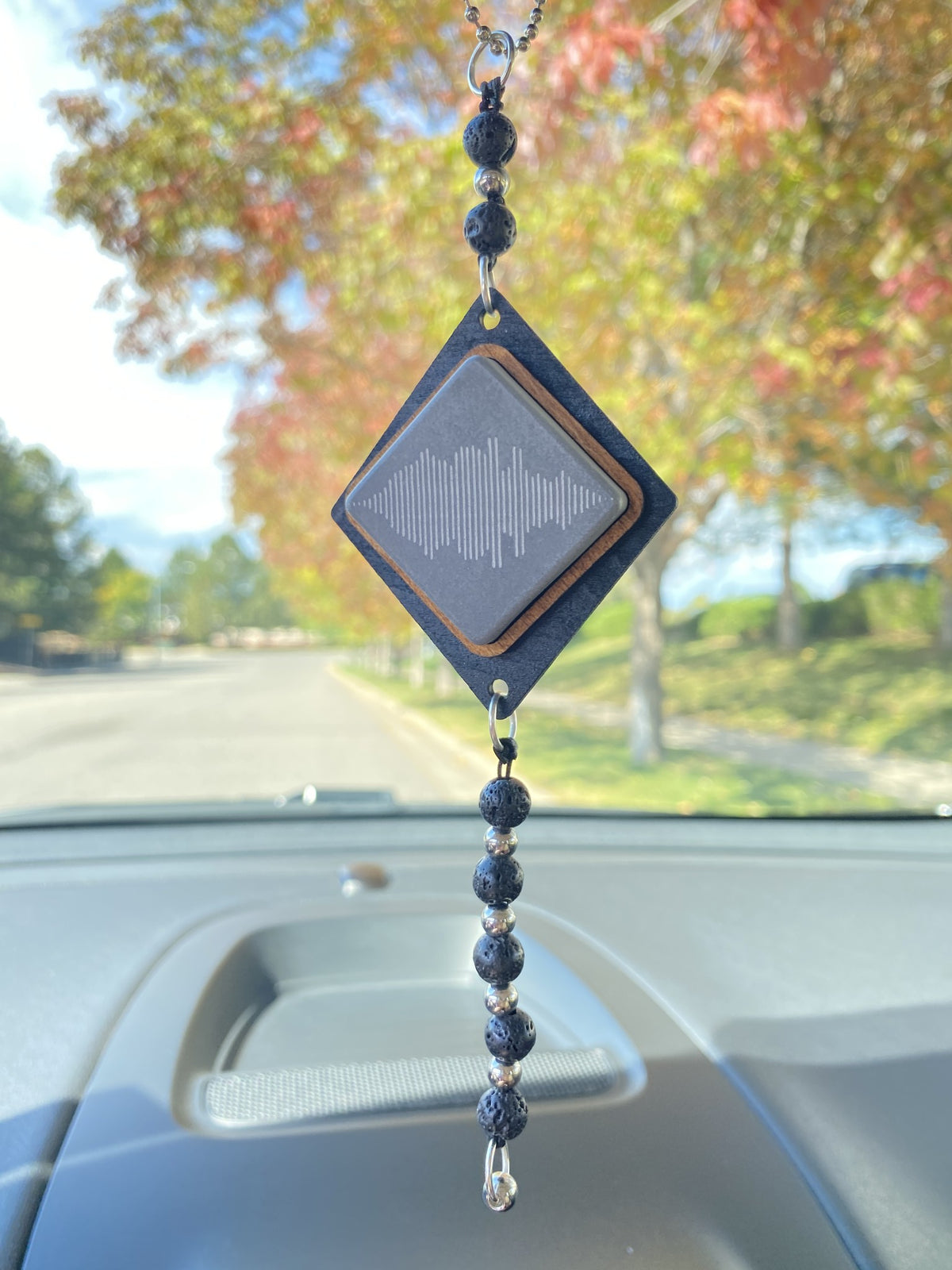 A car charm gray with engraved sound wave