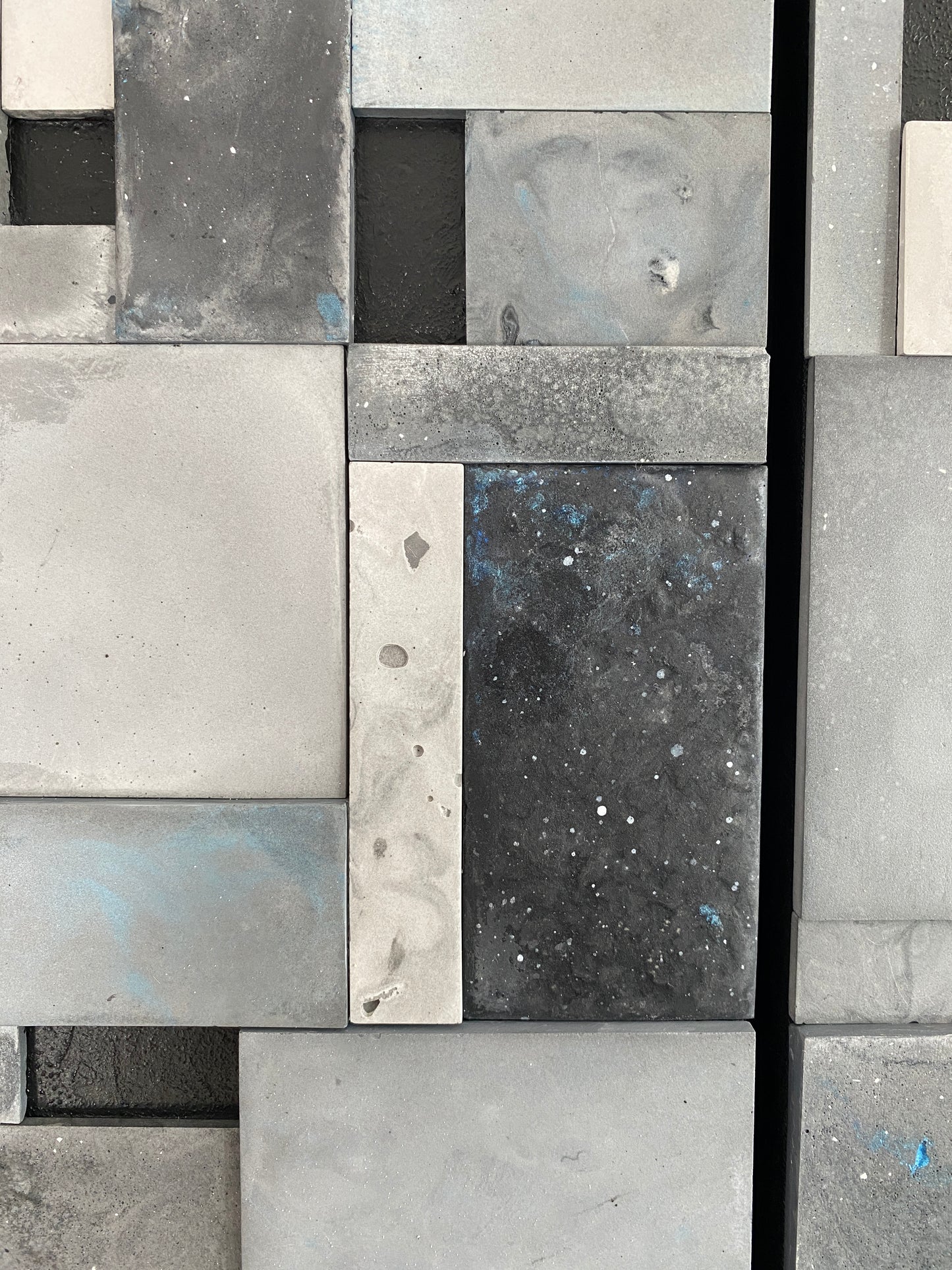 Close-up of a mosaic tile pattern with various shades of gray and black.