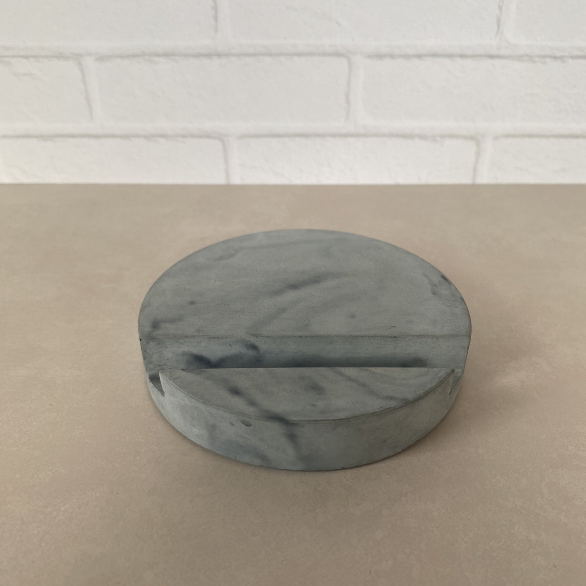 Gray and black marbled round concrete stand.