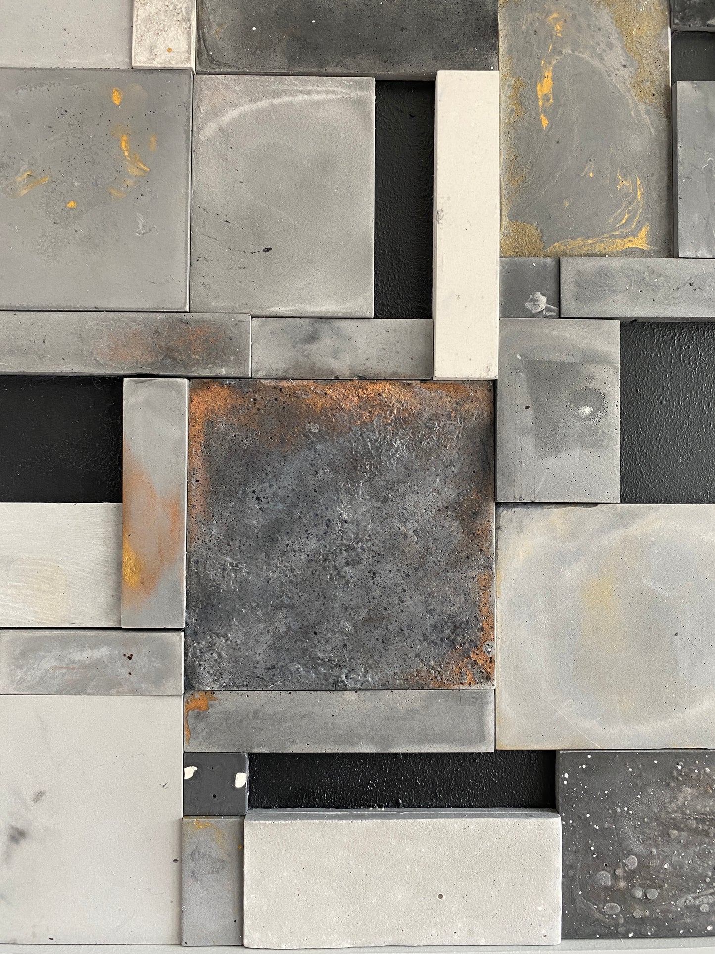 Upclose photo of mosaic wall art triptych with golds and bronze textures in black floating frame.