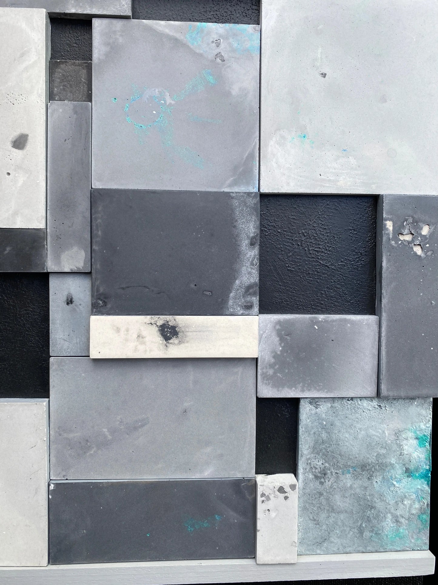 Pattern of square tiles in various shades of gray and black.