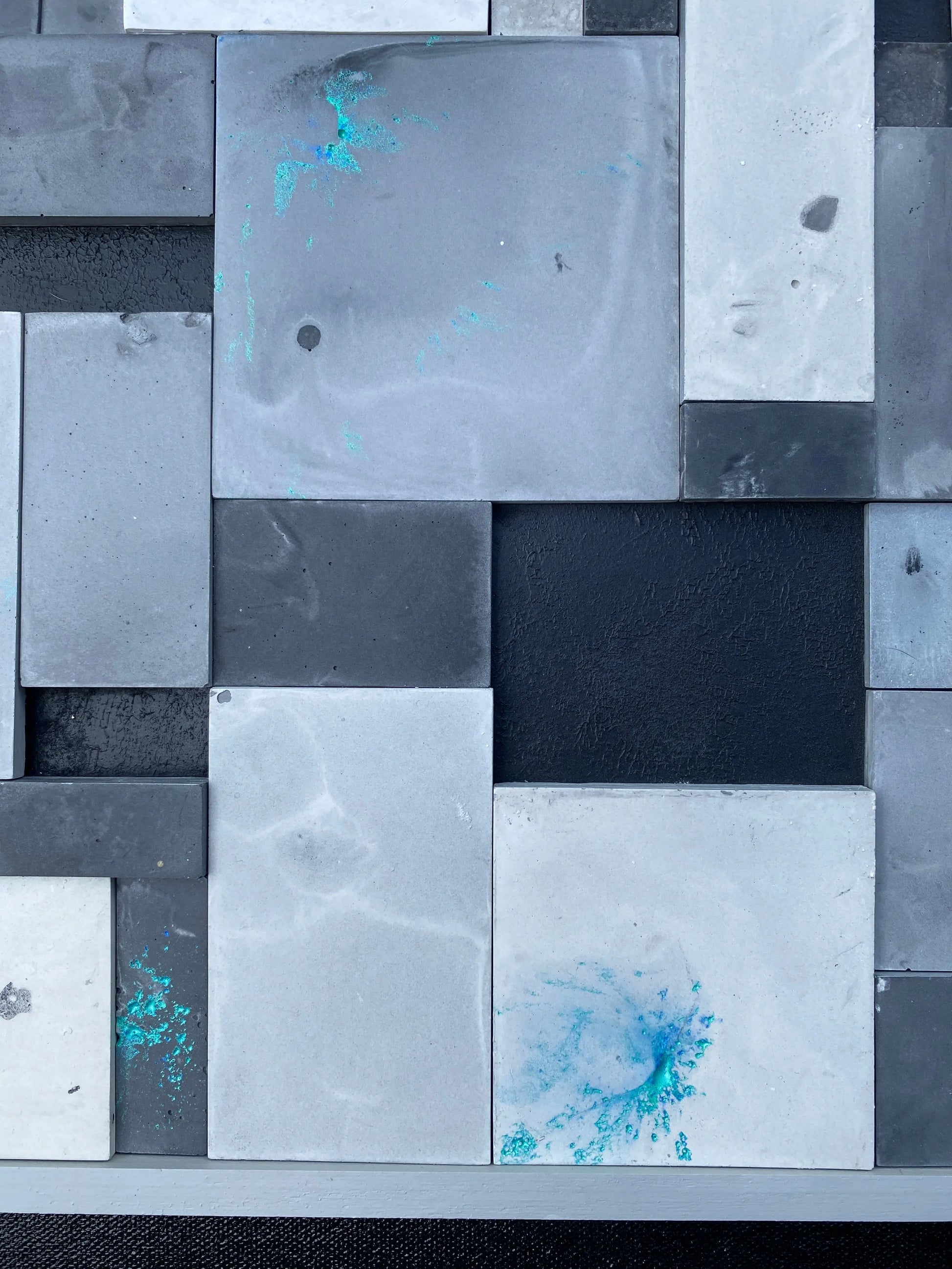 Abstract art piece with geometric shapes in gray, black, and blue.
