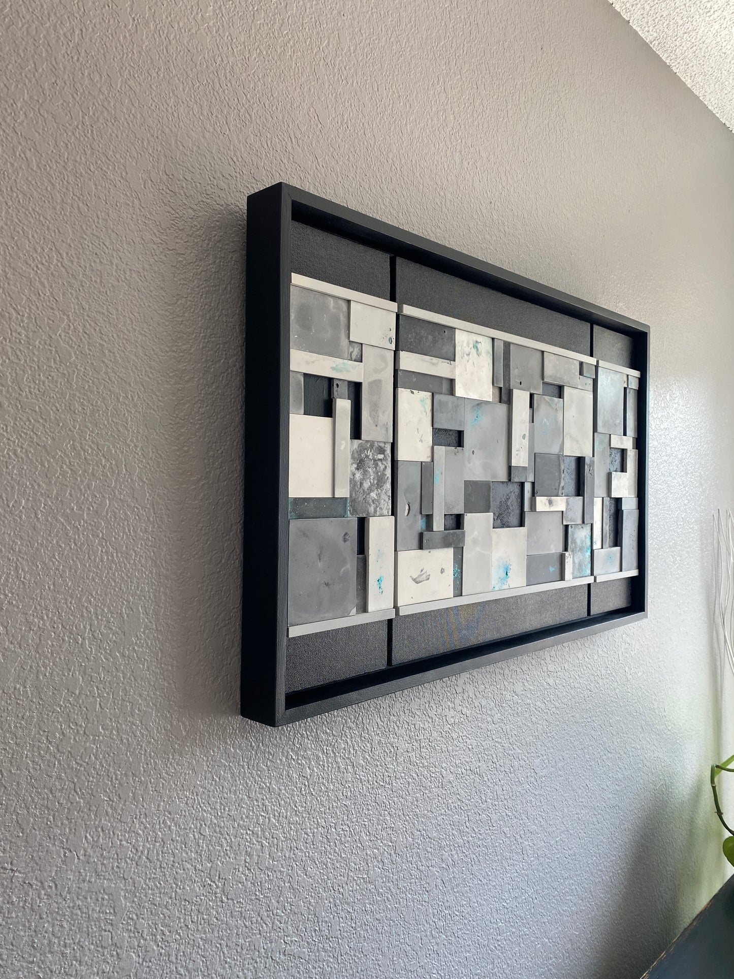 Side view of Ocean’s Memory from the right, highlighting dimensional mosaic tiles and painted wooden trim on grey wall.
