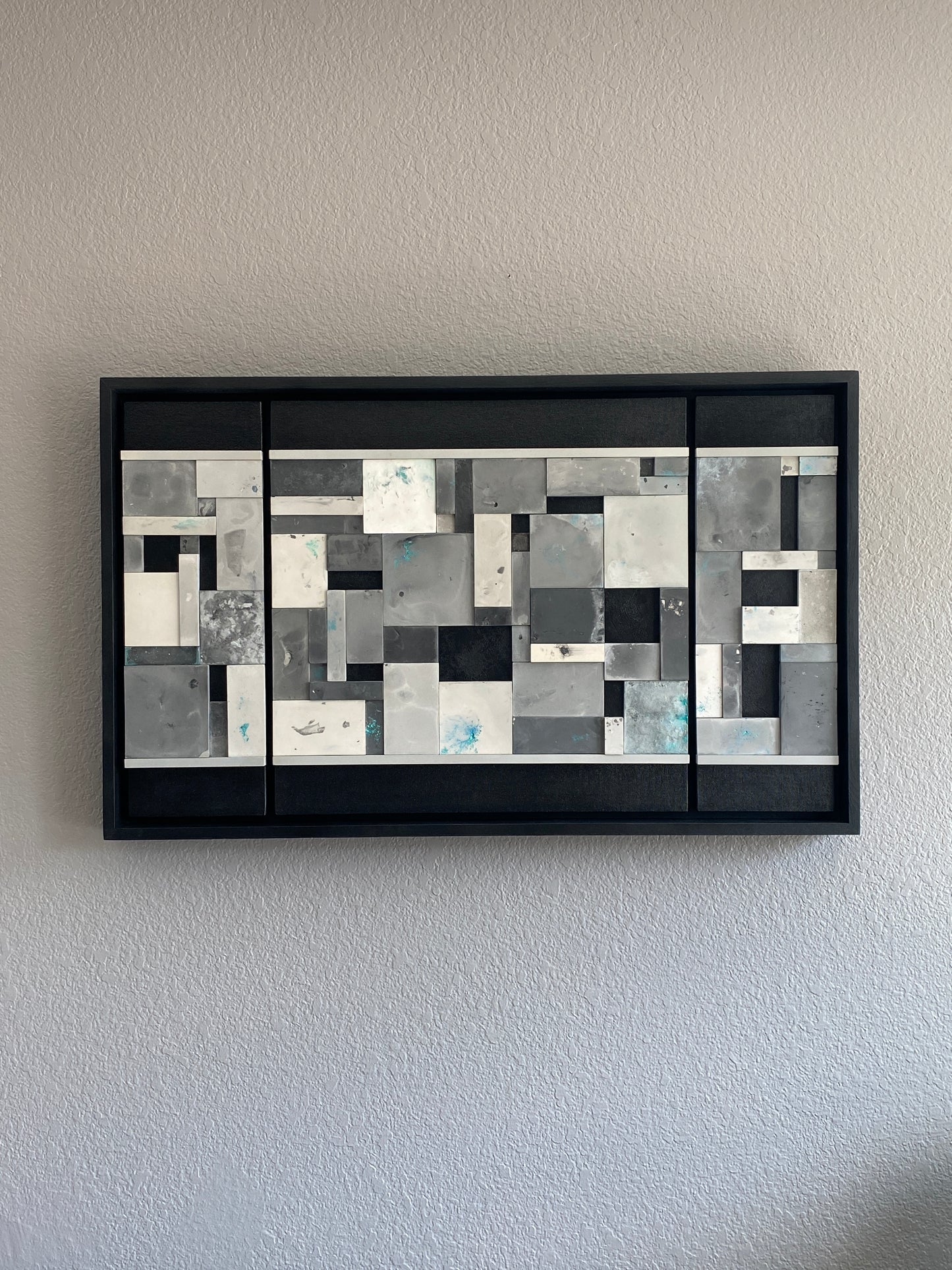 Close-up of Ocean’s Memory showing layered acrylic resin tiles with shimmering mica pigments and textured paint details on grey wall.

