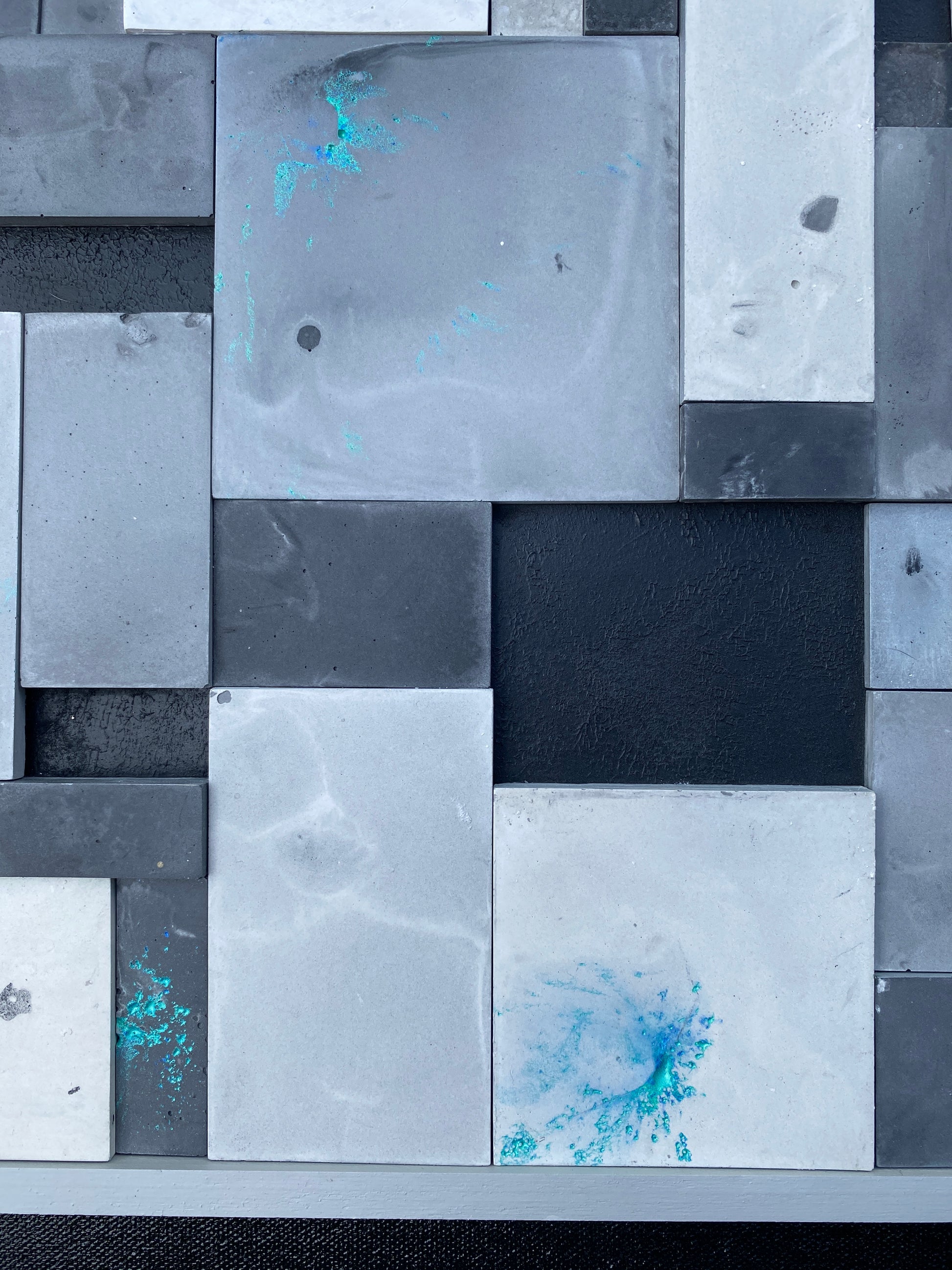 Abstract art piece with geometric shapes in gray, black, and blue.
