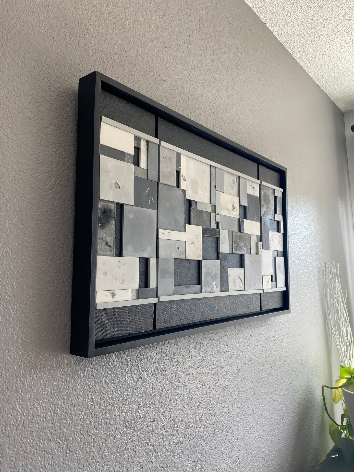 Decorative wall art with geometric pattern on a gray surface.