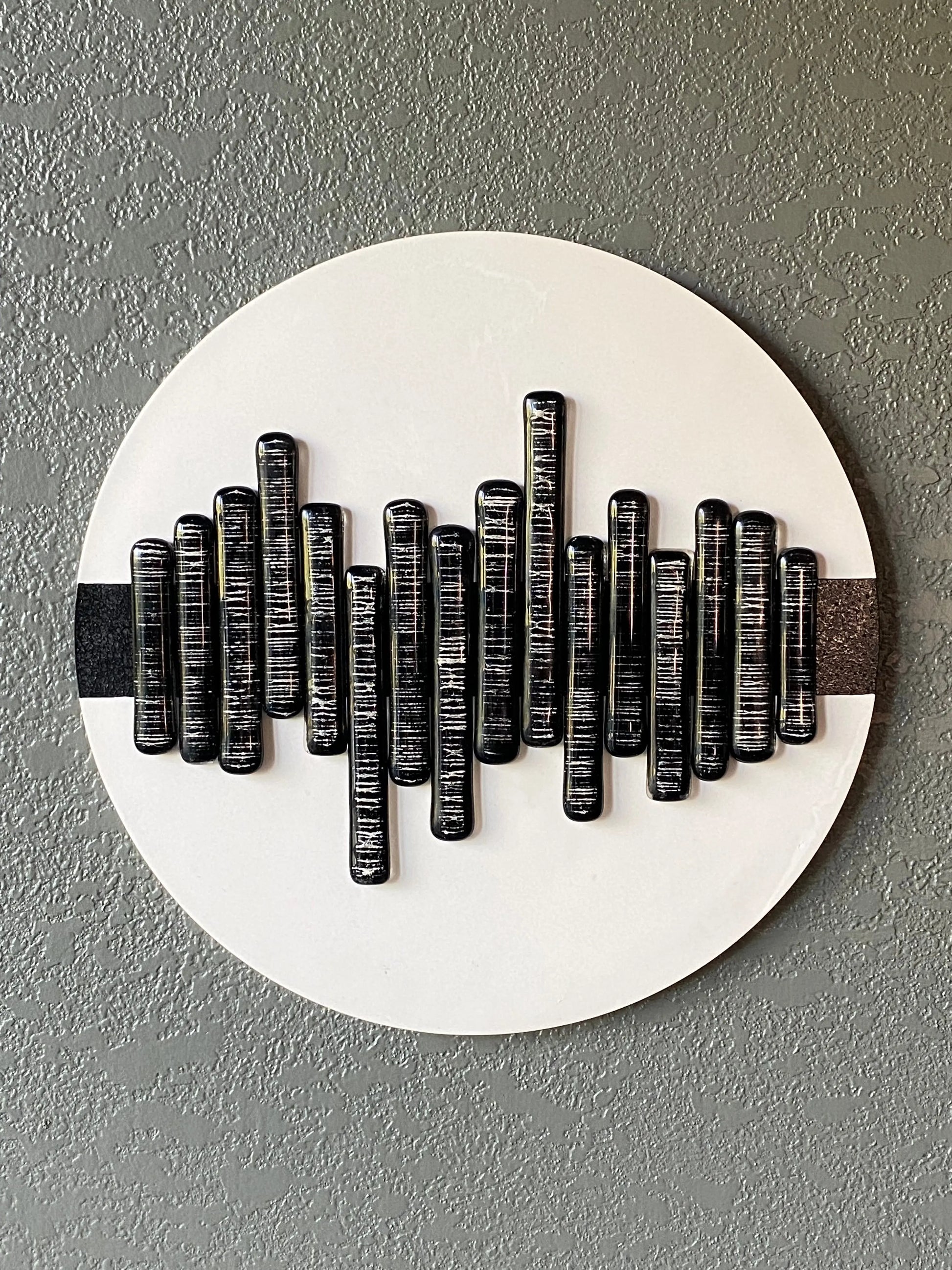 Soundwave cremation ash memorial wall art with glass pieces in wave pattern on white frame and black stripe