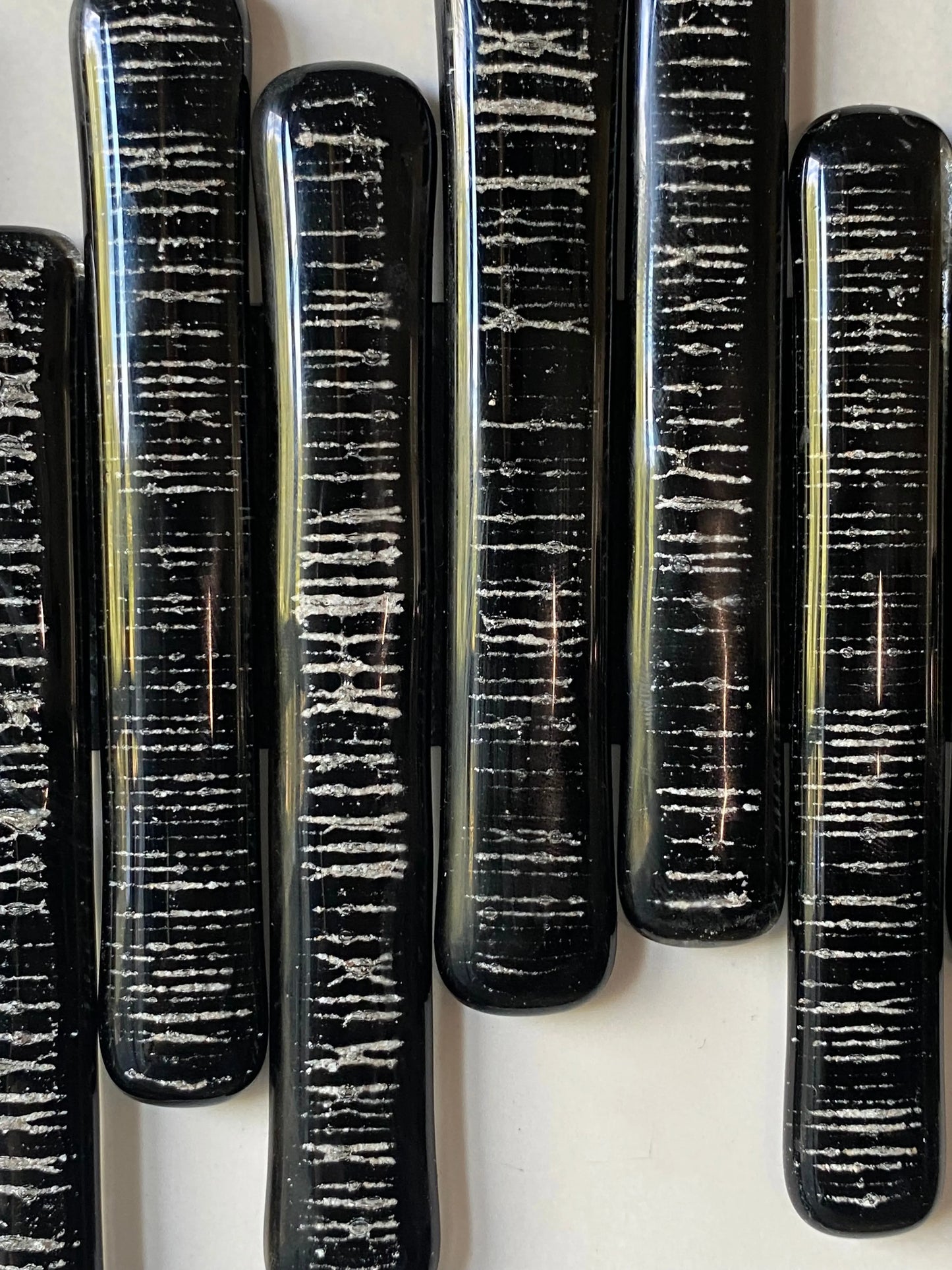 Close-up of glass pieces infused with cremation ash, forming a soundwave pattern symbolizing heartbeat and presence