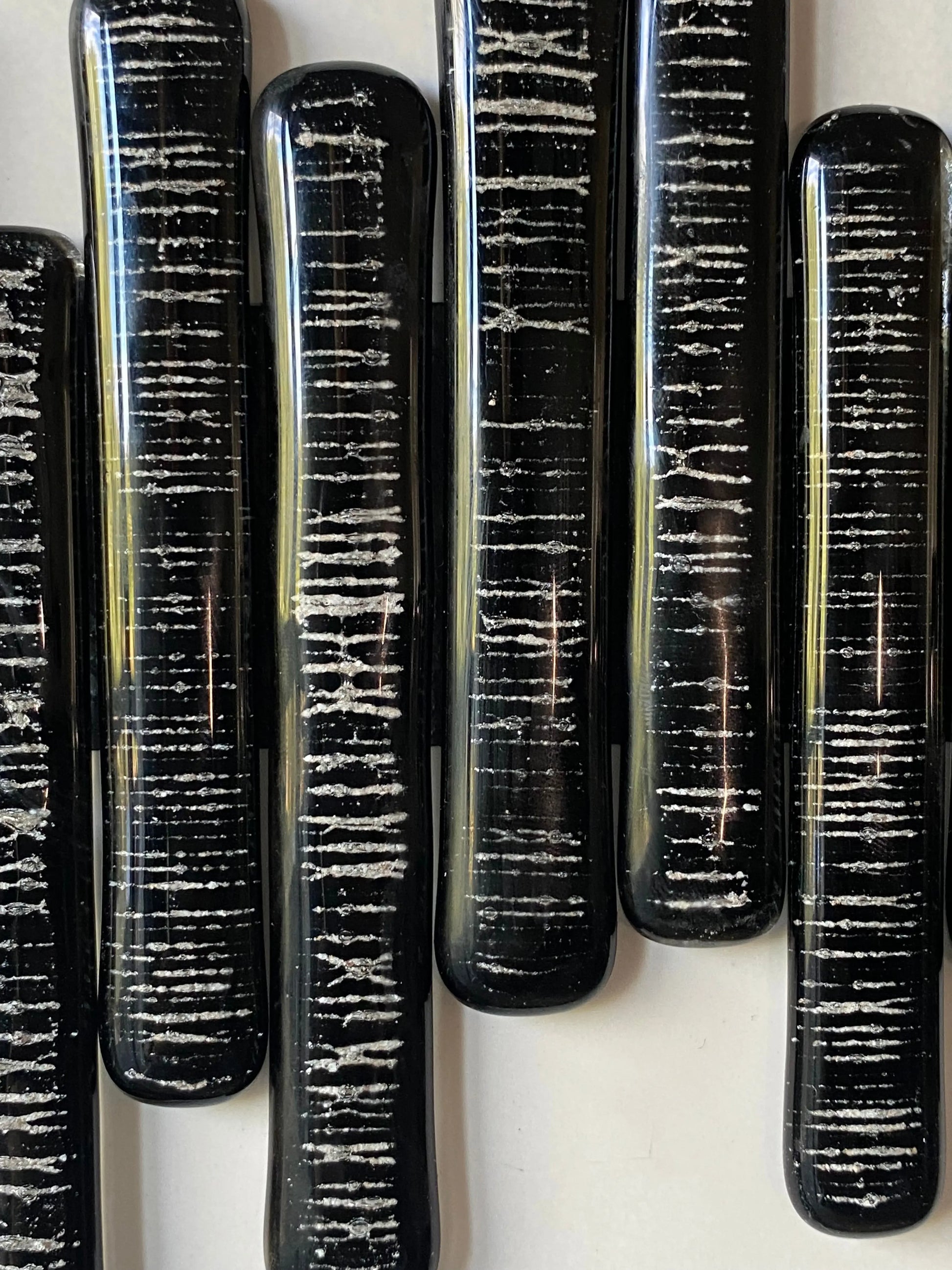 Close-up of glass pieces infused with cremation ash, forming a soundwave pattern symbolizing heartbeat and presence