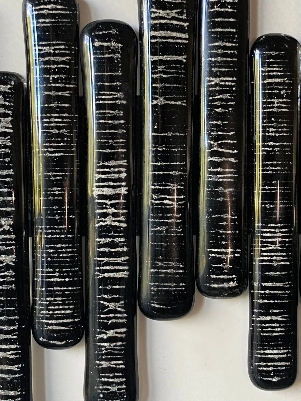 Close-up of glass pieces infused with cremation ash, forming a soundwave pattern symbolizing heartbeat and presence