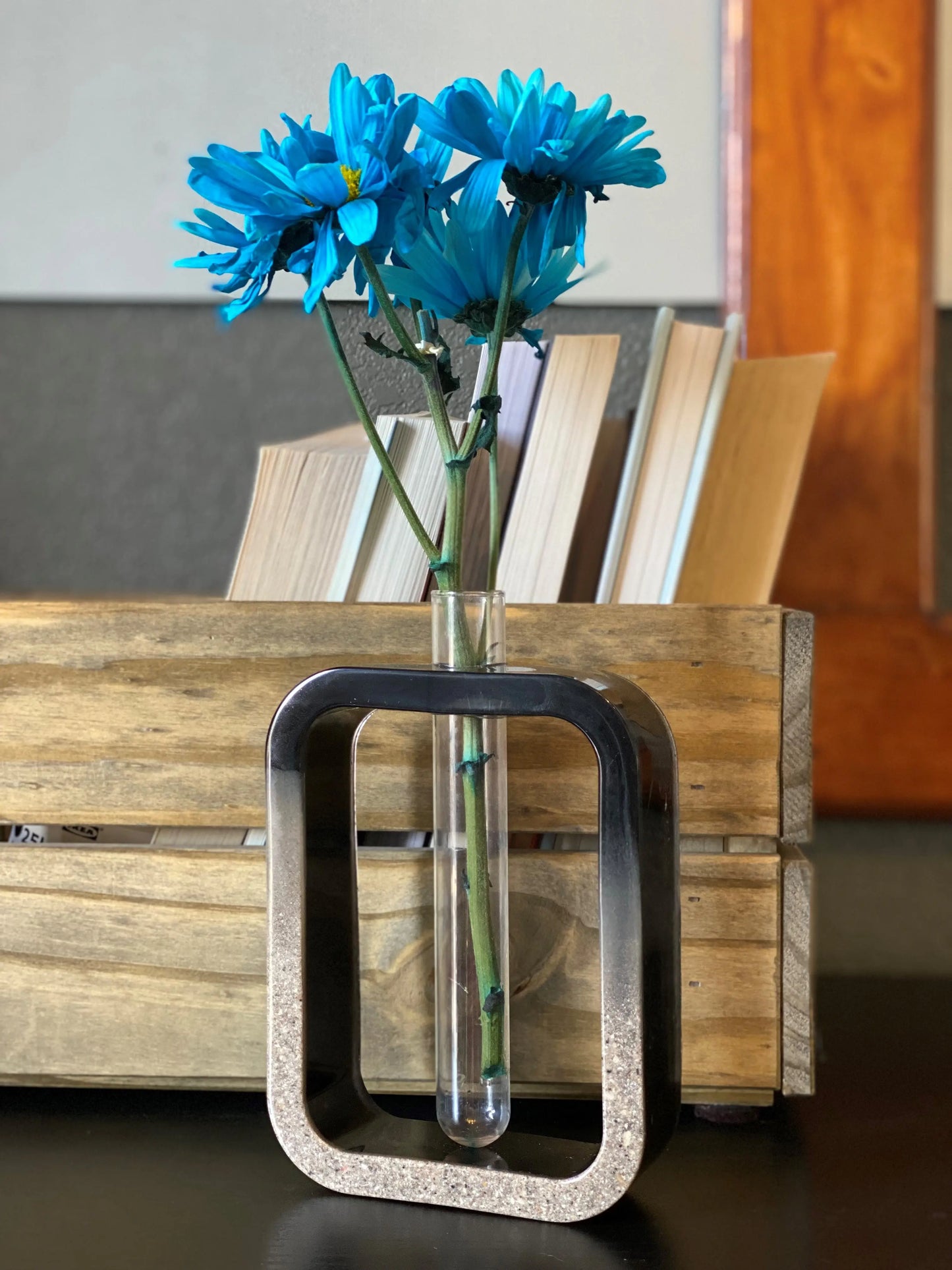 Infused ash vase with blue flowers on a wooden surface