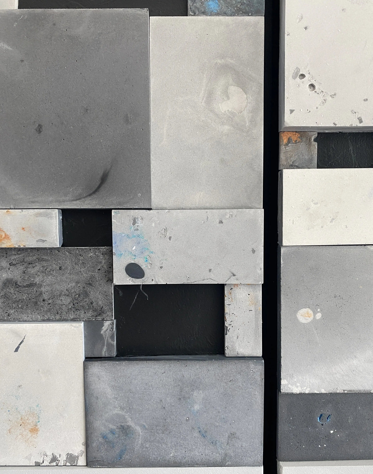 Close-up of a patterned tile with gray, black, and white squares.
