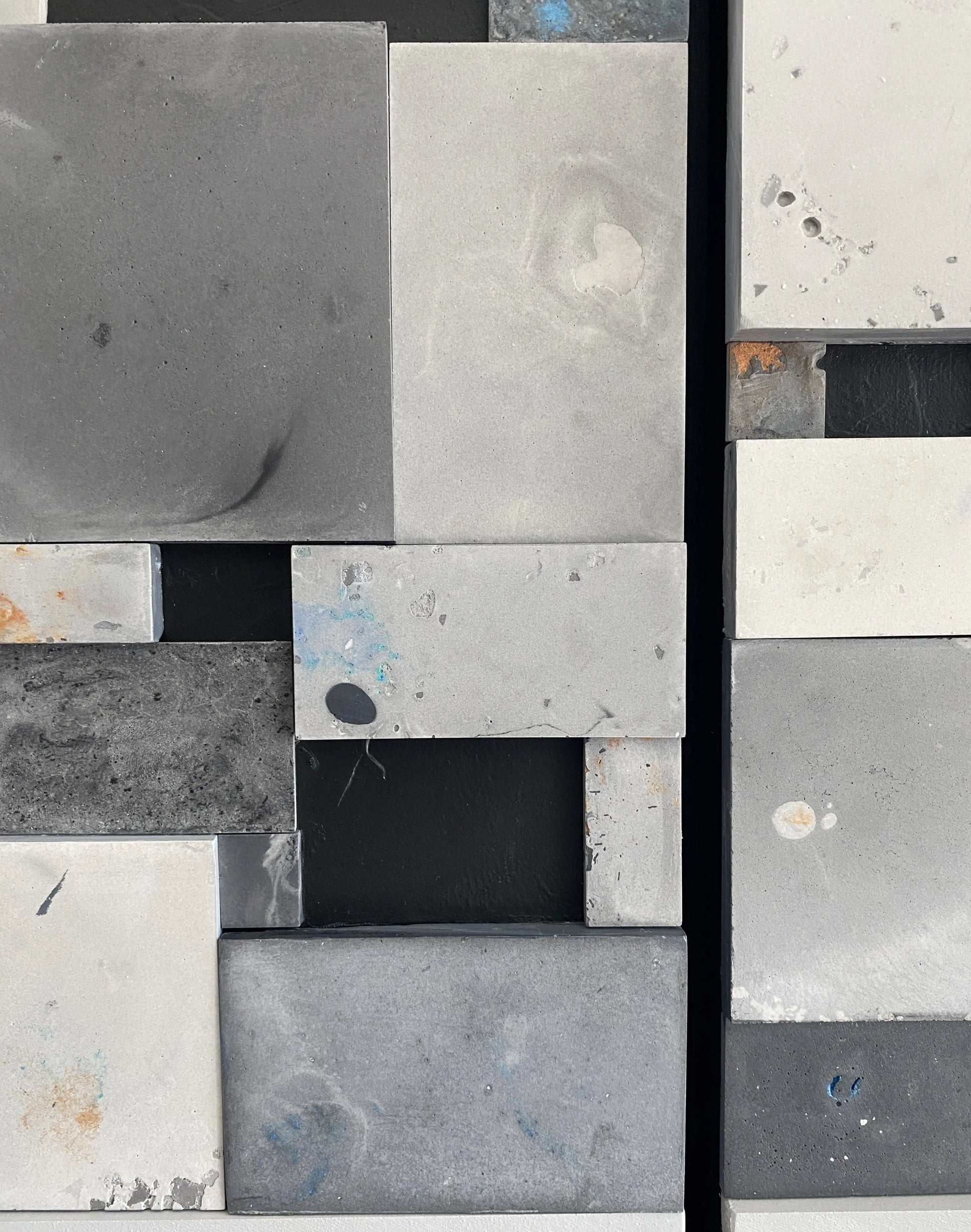 Close-up of a patterned tile with gray, black, and white squares.