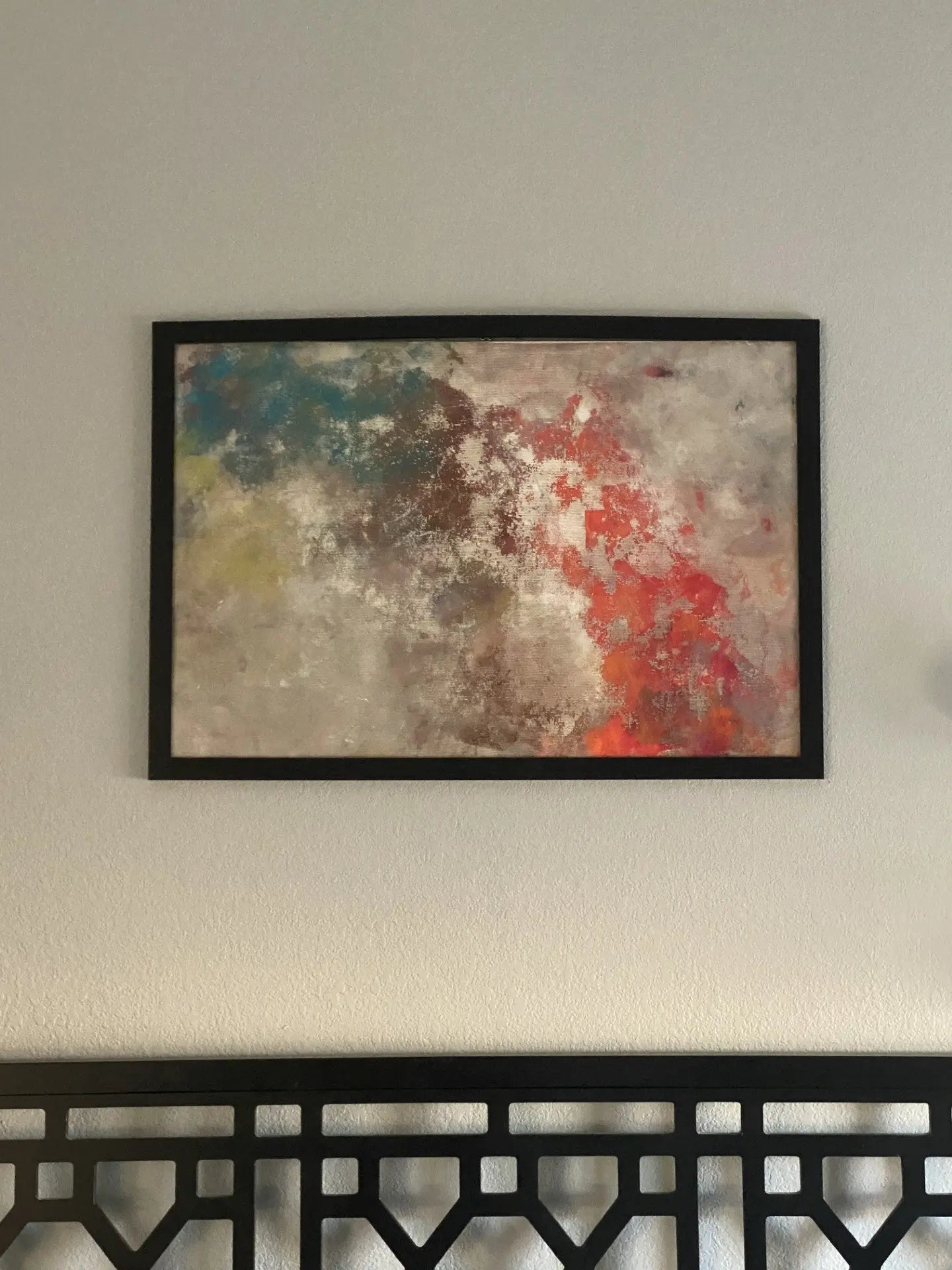 Abstract artwork created with acrylic paint on screen door material, framed in wood with layered, vibrant colors.