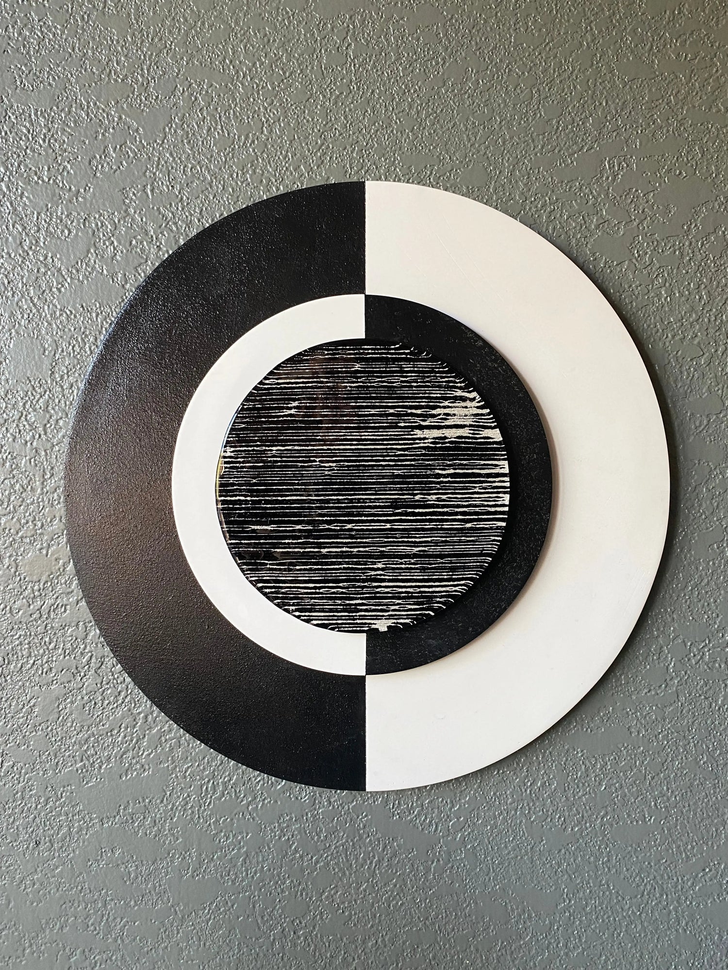 Front view of memorial wall art showing black and white frames, yin yang glass, and textured black stripe